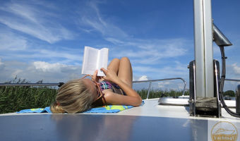 Dit is het echte leven: liggend op het dek onder een prachtig zonnetje van een goed boek genieten