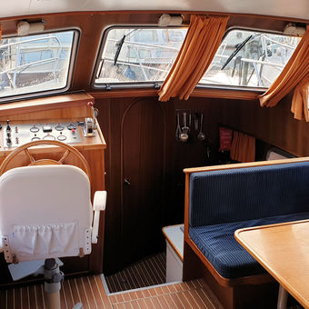 De salon van het motorjacht Carla met binnenstuurstand aan de linkerkant