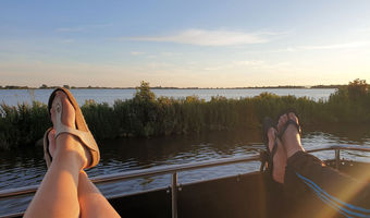 Vanaf het dek met de benen in de lucht genieten van een wijds uitzicht