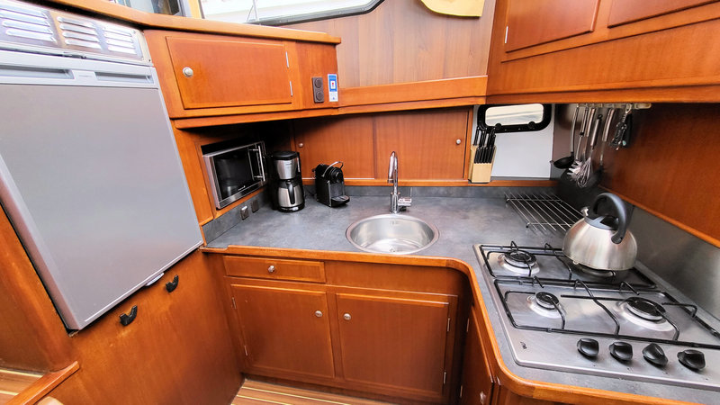Standaard koffieapparaat en Nespresso in de kombuis van de boot, magnetron, koelkast en fornuis