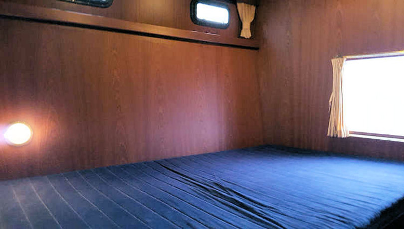 Tweepersoons bed in een achterkajuit van de boot Julia
