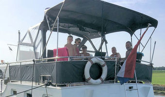Een grote boot, een  groot achterdek, een groot gezelschap aan boord