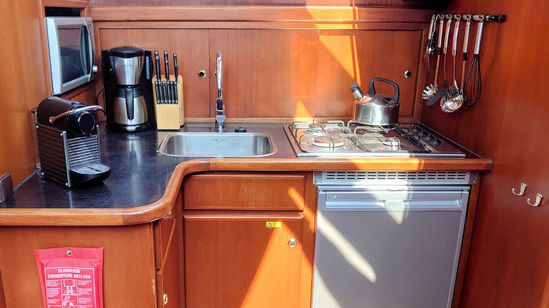 De keuken van de Evita met gasfornuis, standaard koffieapparaat, Nespresso, magnetron en koelkast