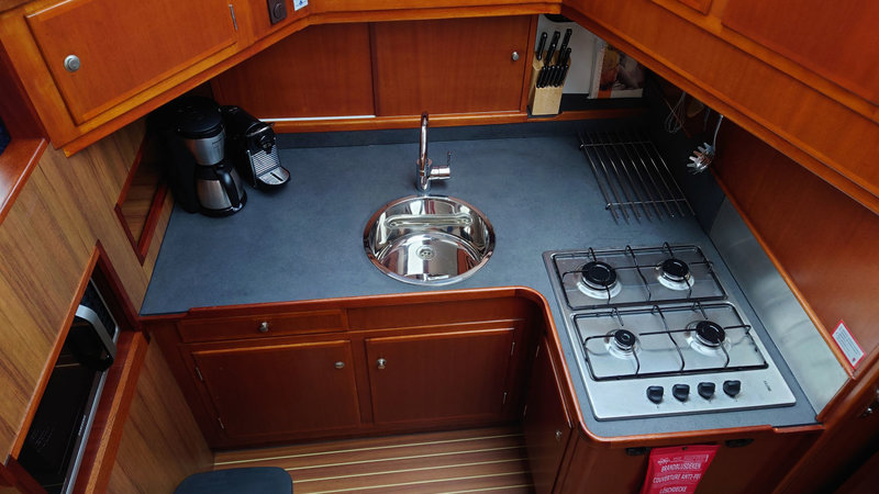 Standaard koffieapparaat en Nespresso in de kombuis van de boot, magnetron, koelkast en fornuis